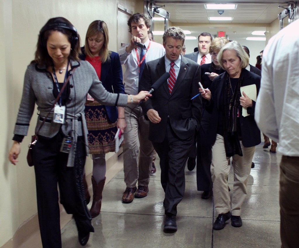Sen. Rand Paul, R-Ky. is pursued by reporters on Capitol Hill on Friday as the Senate considers a $1.1 trillion government-wide spending bill. The House has passed the bill, which would avert a government shutdown.