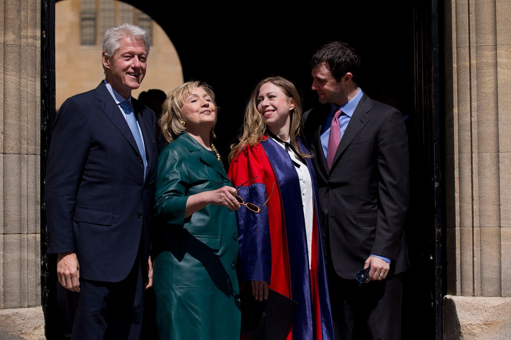 Former U.S. Secretary of State Hillary Rodham Clinton, second left, takes off her sunglasses in this 2014 photograph with her husband former U.S. President Bill Clinton, left, their daughter Chelsea, second right, and her husband Marc Mezvinsky, as they leave after they all attended Chelsea's Oxford University graduation ceremony at the Sheldonian Theatre in Oxford, England.