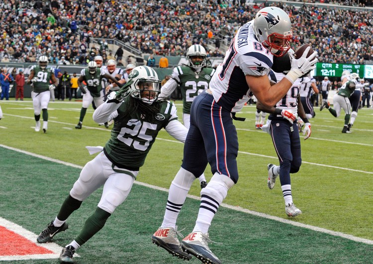 New England Patriots tight end Rob Gronkowski scores a touchdown as New York Jets' Calvin Pryor (25) closes in during the first half of Sunday's game in East Rutherford, N.J. 