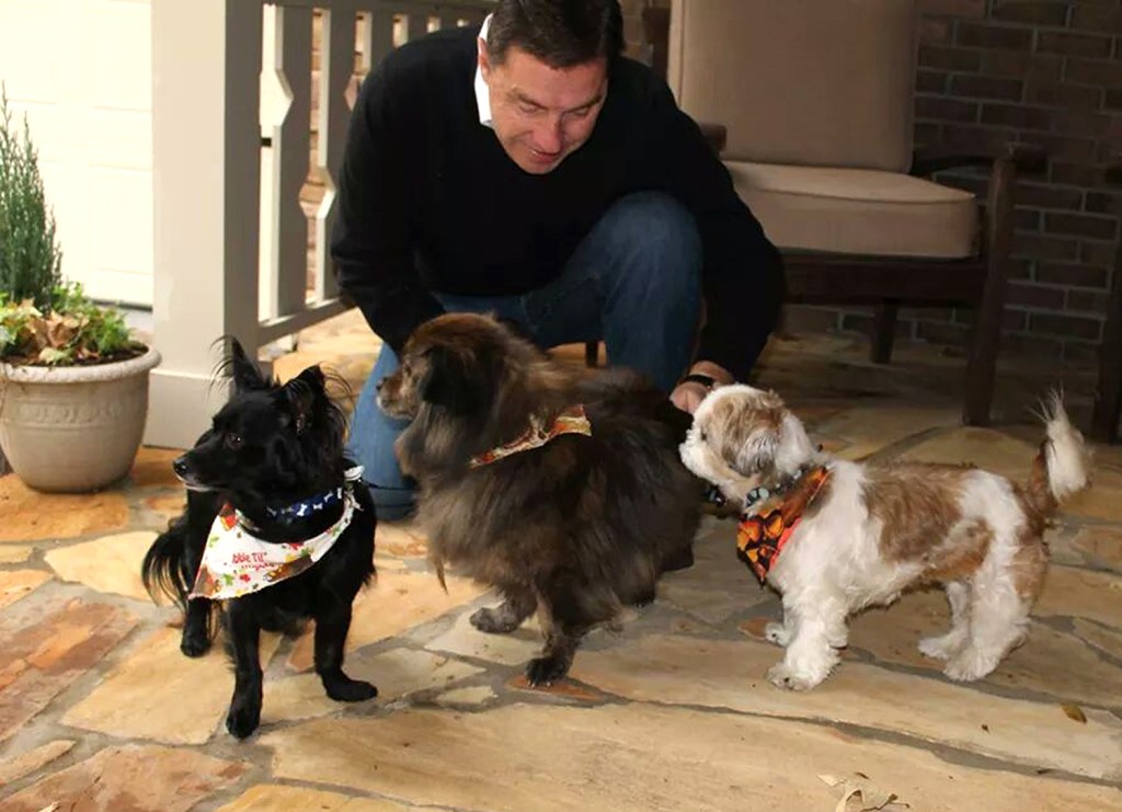 n this Nov. 23, 2014 photo provided by Jan Trantham, Will Trantham kneels by Jackson, left, a Shih Tzu, along with Darcy, center, and Sophie. The Associated Press