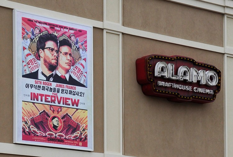 A large poster advertising the movie "The Interview" hangs on the back wall of the Alamo Drafthouse Cinema in Houston on Tuesday. The theater plans to show the film beginning Thursday.