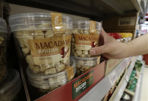A customer picks up a plastic container of Macadamia nuts at a store in Seoul, South Korea, Monday. The Associated Press