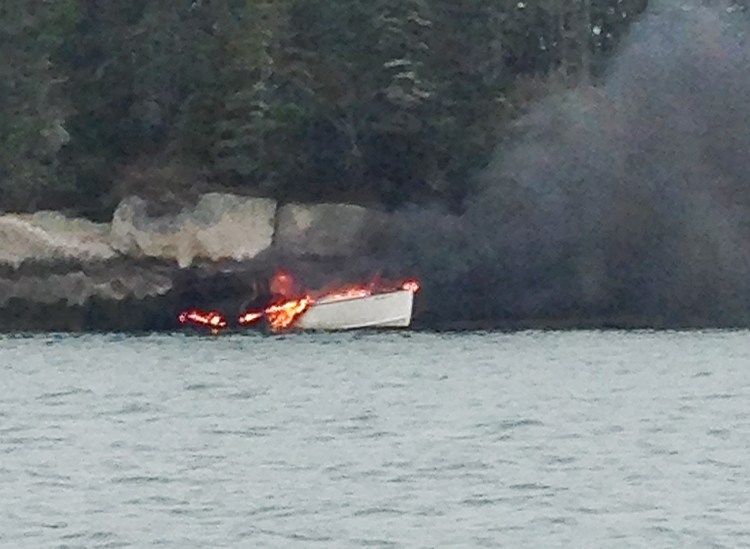 The Midnight Rider, a 25-foot inboard lobster boat, burns near Crane Island on Tuesday where it drifted after David and Blake Anthony jumped overboard and swam to nearby Cedar Island and safety. Maine Marine Patrol photo by Officer Brandon Bezio
