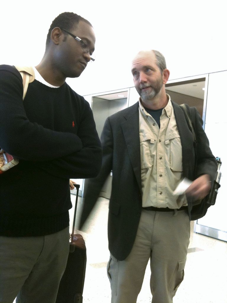 Nate Nickerson, right, executive director of Konbit Sante, talks with Lionel Maledranche at New York's Kennedy Airport on Saturday. Maledranche, a New Jersey doctor, was returning to Haiti to check on his family. Nickerson is trying to reach Cap-Haitien, Haiti's second-largest city.