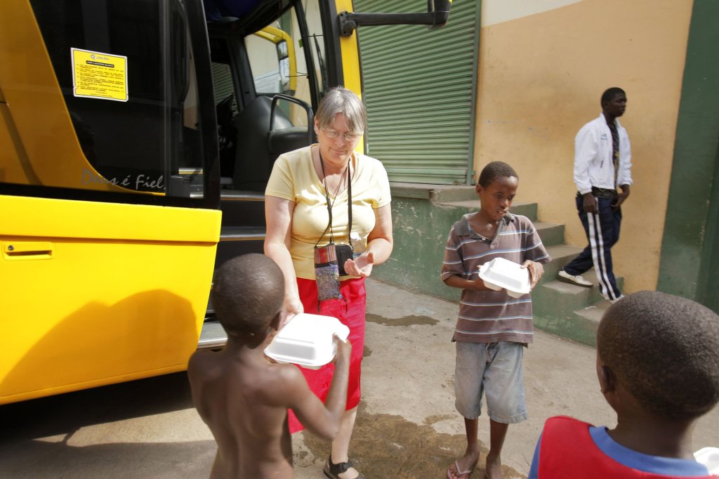 Terry Johnston of Jefferson hands a lunch to a boy in the border town of Dajabon in the Dominican Republic on Sunday. She had received the food on her bus trip to Cap-Haitien, in northern Haiti. Johnston has been visiting Terrier Rouge, a nearby town, since 2002 and has set up a network through her church to help the town's residents.