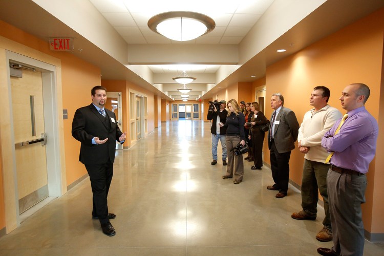 Ken Cianchette, left, project manager with ELC Management, the company that oversaw construction of the building in South Portland that will house offices of Maine's Department of Health and Human Services and Department of Labor, gives a tour of the building on Monday.