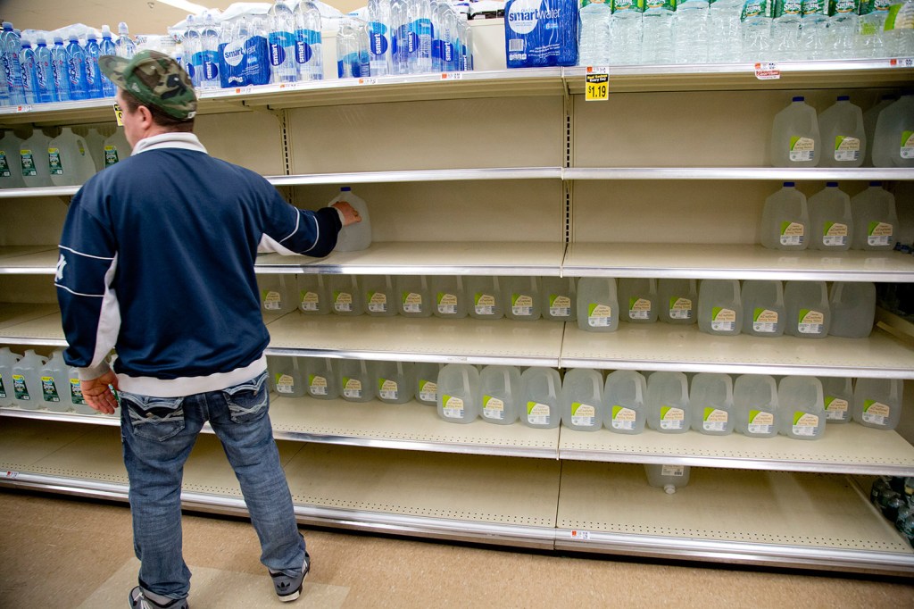 A shopper grabs a gallon of water at the Hannaford supermarket on Forest Avenue in Portland on Monday, the day before the blizzard hit. Bottled water is the top item to fly off Hannaford stores' shelves before a big storm.
