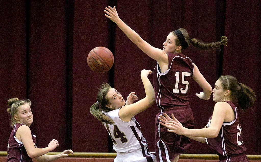 Hayden Campbell (14) of Thornton Academy and Kristen Curley (15) of Gorham, compete for a rebound during a girls basketball game, Monday, as Gorham's Caitlyn Hawxwell, at left, and Emily Esposito, at right, look on.  Gabe Souza / Staff Photographer