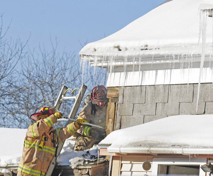 Firefighters look for hot spots after extinguishing a fire Friday on Main Street in Richmond. 