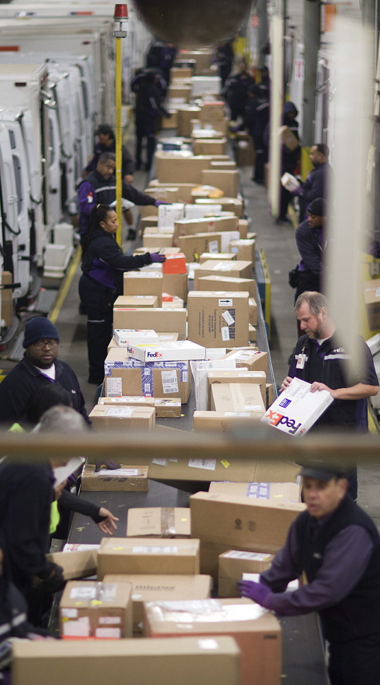 Packages are sorted on a conveyor belt before being loaded onto trucks for delivery last month at a FedEx facility in Marietta, Ga. This year, FedEx and UPS each delivered 98 percent of express packages on time by Christmas Eve, thanks in part to each hiring 10,000 extra seasonal workers.