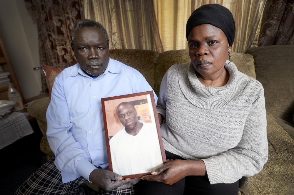 Robert Lobor and Christina Marring hold a photograph of their son Richard Lobor at the family’s home in Portland on Dec. 9. Lobor died by gunshot in Portland recently. The photograph of Richard is from April of 2014. Like many refugees, Lobor was exposed to trauma as a child.