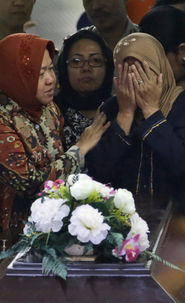 A woman weeps over the casket of AirAsia crash victim Hayati Lutfiah, in East Java, Indonesia, on Thursday.