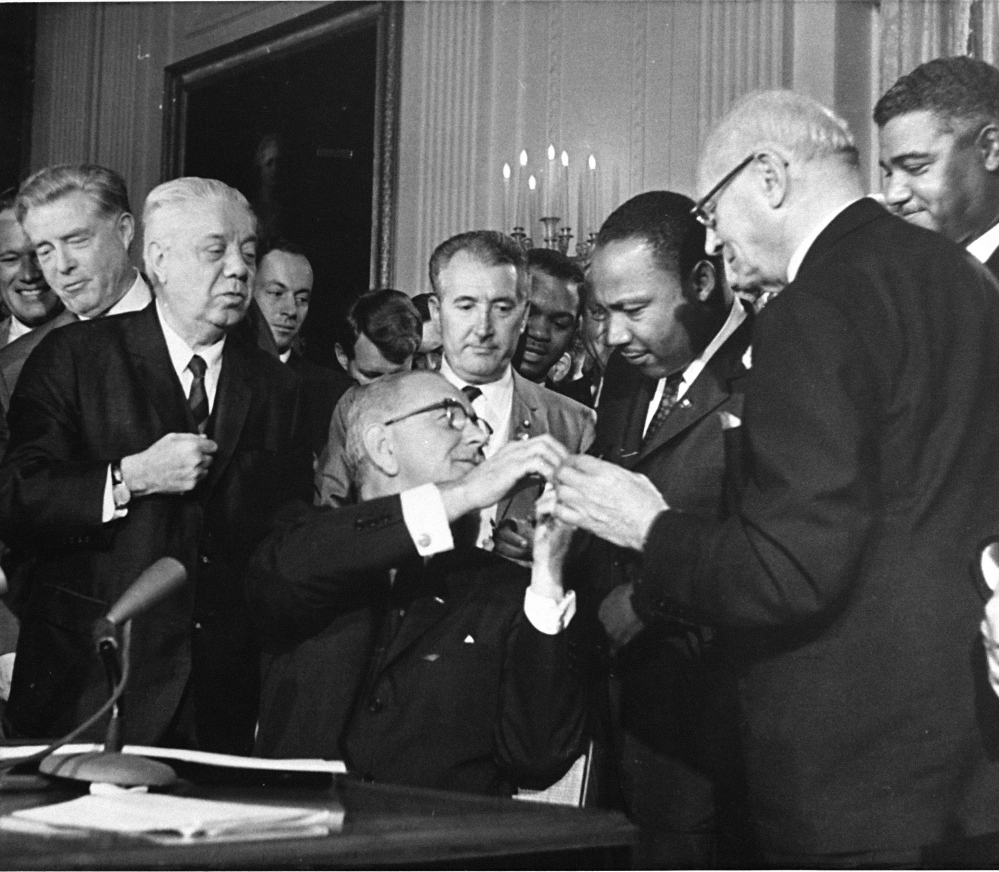 The Rev. Martin Luther King, third from right, head of the Southern Christian Leadership Conference, was among national figures present on July 2, 1964, as President Lyndon B. Johnson, seated, signed the Civil Rights Bill.