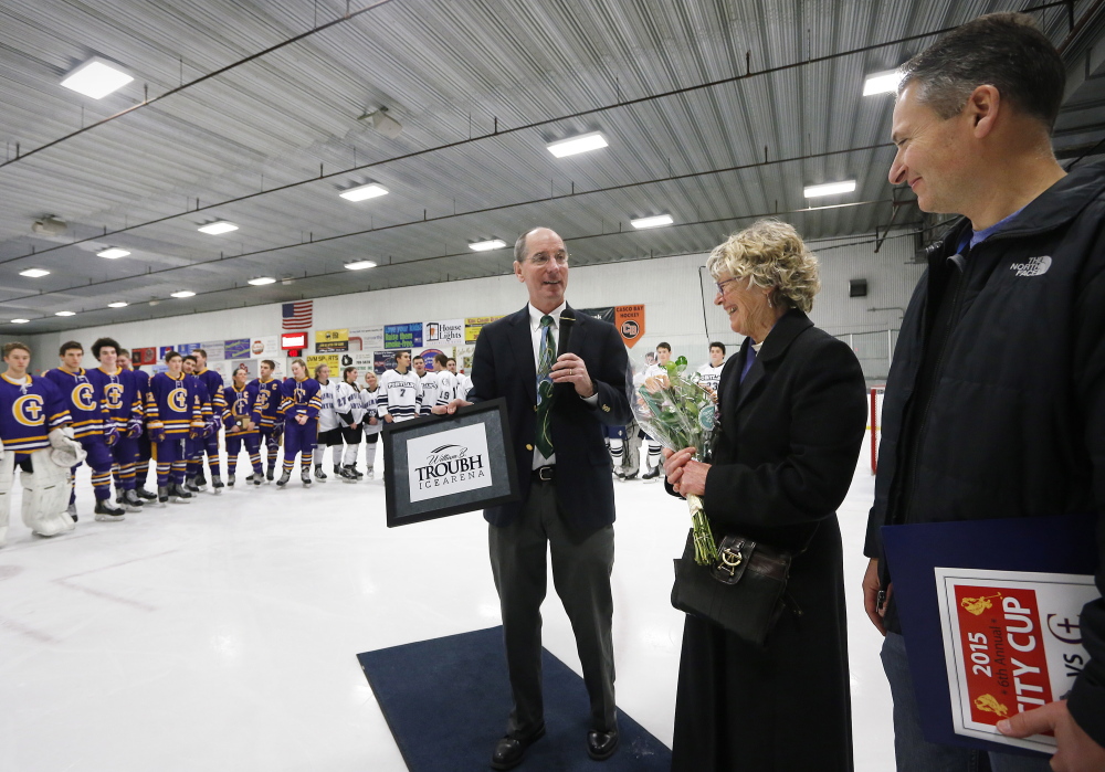 Jerry Conley, president of the Portland Middle School Hockey Association, presents a plaque to Nancy Troubh, William B. Troubh’s widow, and their son, Jed Troubh, before the City Cup. Her husband “always said he wanted to give back to the city,” Nancy Troubh said.