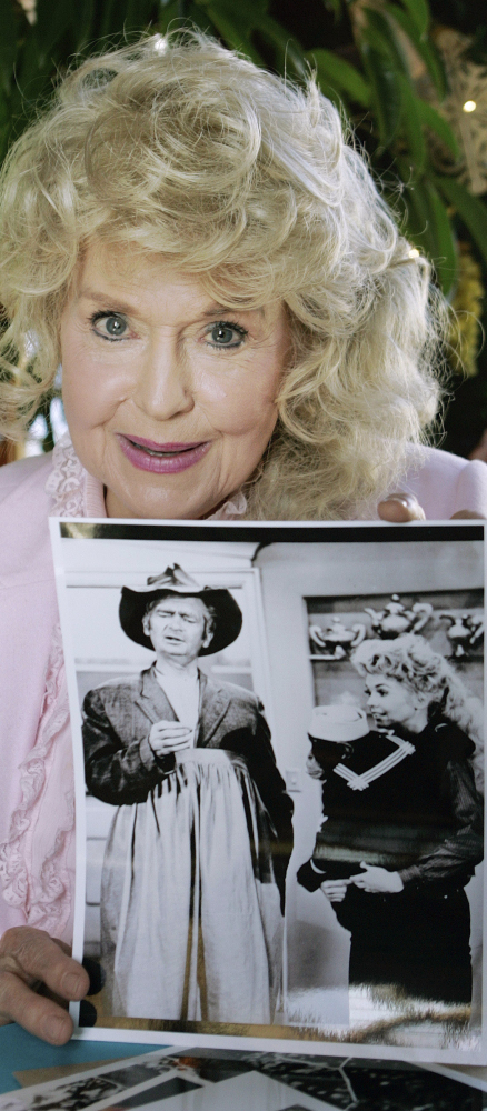 Donna Douglas, who starred as Elly May Clampett in the television series “The Beverly Hillbillies,” holds a publicity photo of herself from the show in Baton Rouge, La., in 2009. Douglas died Thursday at age 82.