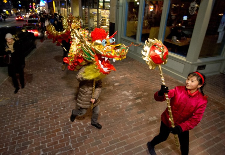 Students from the Chinese & American Friendship Association of Maine Chinese School carry a large dragon along Congress Street on Friday to promote their Chinese New Year celebration, which will take place Feb. 7 at the Westbrook Performing Arts Center. Photos by Gabe Souza/Staff Photographer