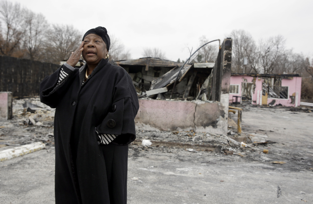 Juanita Morris wipes away a tear outside the remains of her business in Dellwood, Mo., a town next to Ferguson. Juanita’s Fashions R Boutique was destroyed in rioting on Nov. 24, but money raised from a crowd-funding website will help her rebuild.
