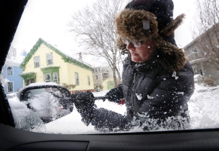 JAN. 4: Katie Benedict of Portland clears snow and ice from her vehicle after an overnight snowstorm. Mainers spent that Sunday shoveling out from a storm that dropped between 4 and 6 inches in most areas. 