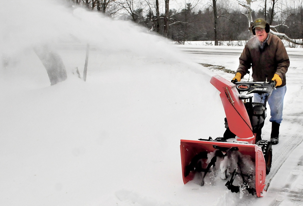 Ken Tozier uses his snowblower to clear off the three inches of snow off his driveway before freezing rain developed at his home in Unity on Sunday.  David Leaming/Staff Photographer