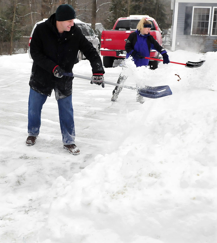 Working as a team Peter and Lisa Hallen shovel snow at their home in Waterville on Sunday. David Leaming