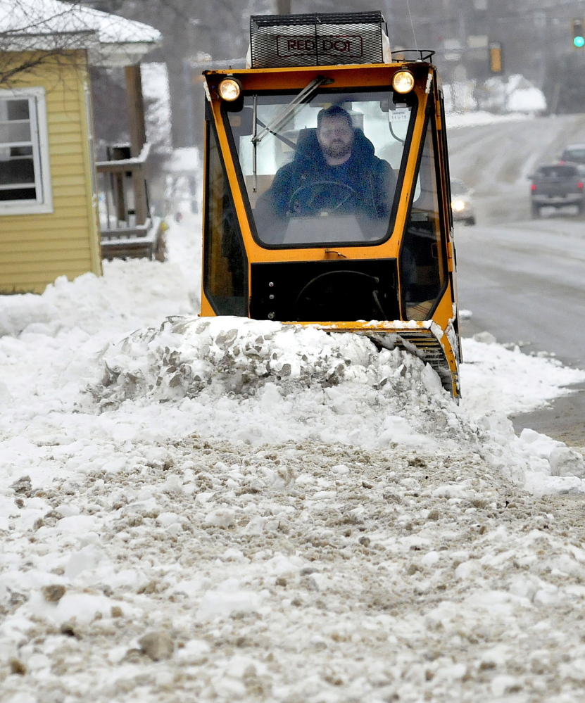 WATERVILLE,ME.-January 4: Waterville Public Works employee Kirk Lachance clears sidewalks of the snow that fell on Sunday, January 4, 2015. (Photo by David Leaming/Staff Photographer)