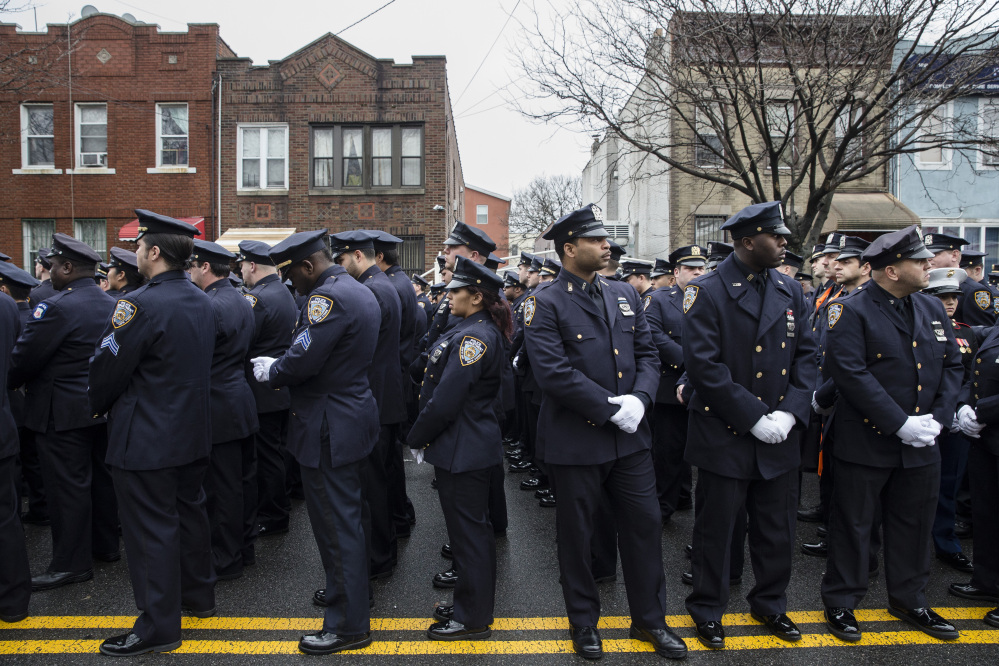 Police officers turn their backs as Mayor Bill de Blasio speaks during the funeral of New York Police Department Officer Wenjian Liu at Aievoli Funeral Home, Sunday, Jan. 4, 2015, in the Brooklyn borough of New York. Liu and his partner, officer Rafael Ramos, were killed Dec. 20 as they sat in their patrol car on a Brooklyn street. The shooter, Ismaaiyl Brinsley, later killed himself. (AP Photo/John Minchillo)