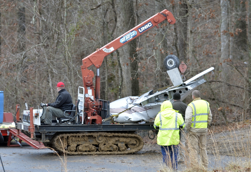 Salvage workers bring out part of a Piper PA-34’s fuselage, wing, and landing gear from a crash site Sunday in Kuttawa, Ky. The plane went down in a deeply wooded area and special machinery was required to remove it.