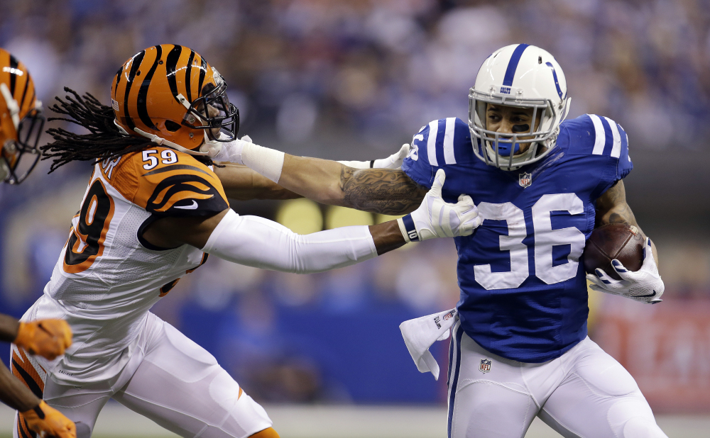 Indianapolis Colts running back Dan Herron runs against Cincinnati Bengals outside linebacker Emmanuel Lamur in the first half Sunday in Indianapolis. The Colts won, 26-10.