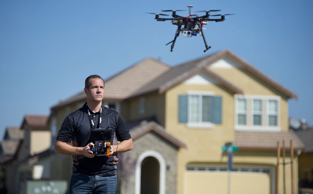 A real estate agent uses a helicopter drone to take video of a Sacramento, Calif., home. An FAA ban on the commercial use of drones is hard to enforce.