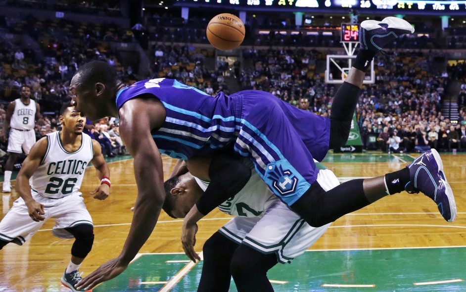 Charlotte Hornets center Bismack Biyombo tumbles over Boston Celtics forward Jared Sullinger on a rebound during the first quarter of Monday night’s game in Boston.