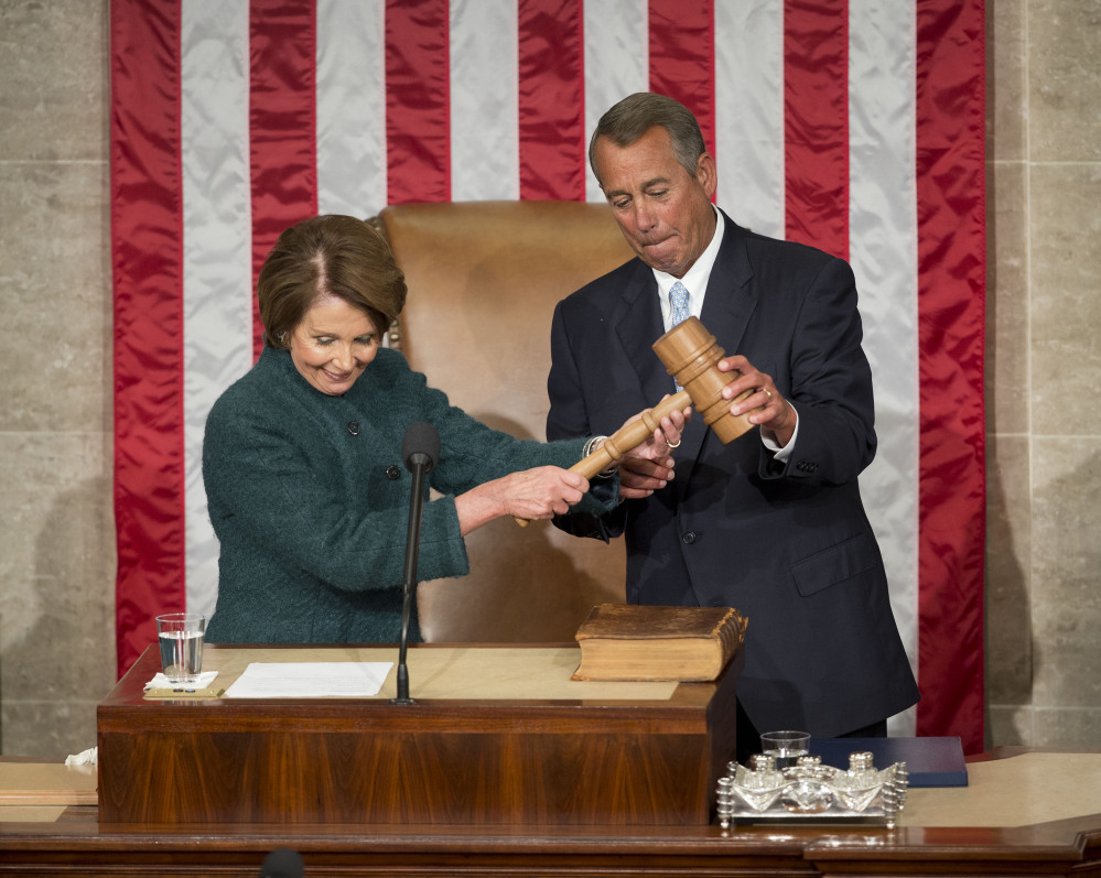 House Speaker John Boehner of Ohio is handed the gavel from House Minority Leader Nancy Pelosi of California on Tuesday on Capitol Hill in Washington after being re-elected for a third term to lead the 114th Congress, as Republicans assume full control for the first time in eight years.