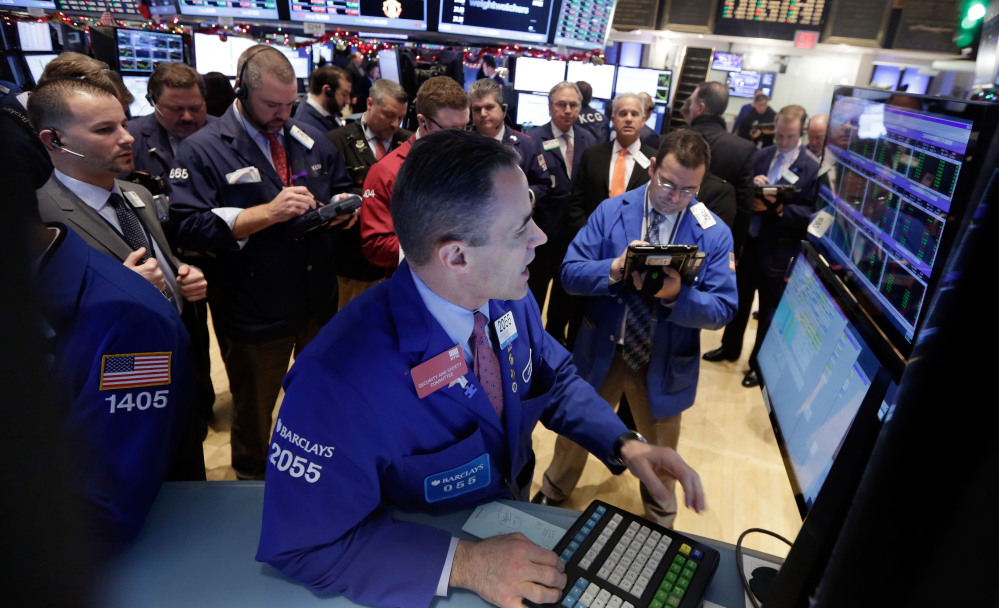 Traders gather at the post of specialist Jason Hardzewicz, foreground, on the floor of the New York Stock Exchange on Tuesday.