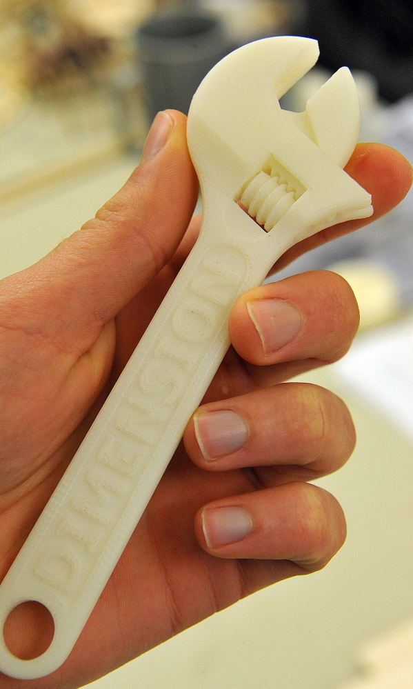 A student holds a working adjustable crescent wrench built in a 3D printer from a computer drawing in the manufacturing lab at Butler County Community College.