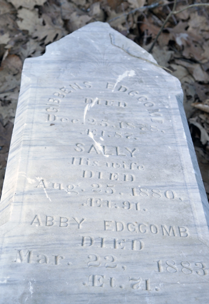 An obelisk grave marker with names on all four sides has toppled to the bottom of the hill at Edgecomb cemetery in Gardiner.