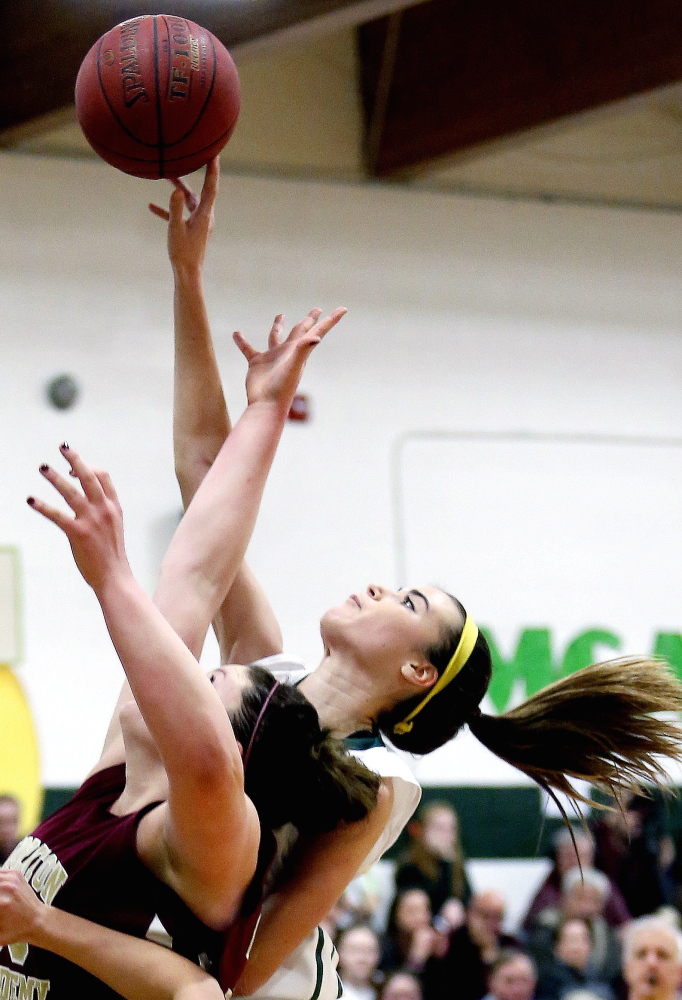 McAuley's Margaret Hatch gets her finger on the ball just over the outstretched arms of Thornton Academy's Victoria Lux during the second half of a girls' high school basketball game Tuesday.
