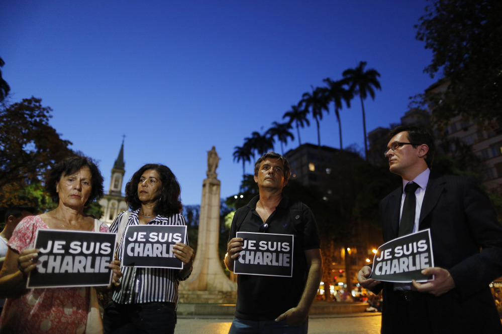 People in Rio de Janeiro, Brazil, hold signs that read in French “I am Charlie,” in solidarity with those killed Wednesday at the Paris offices of the weekly newspaper Charlie Hebdo. Masked gunmen stormed the offices of the satirical newspaper, which caricatured the Prophet Muhammad.