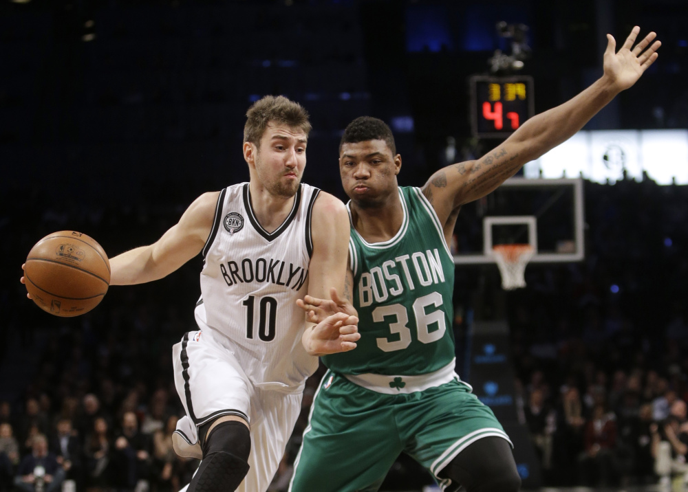 The Brooklyn Nets’ Sergey Karasev drives past the Celtics’ Marcus Smart during the first half of Wednesday night’s game in New York. The Celtics trailed by 11 points in the first half but gradually pulled ahead after halftime.