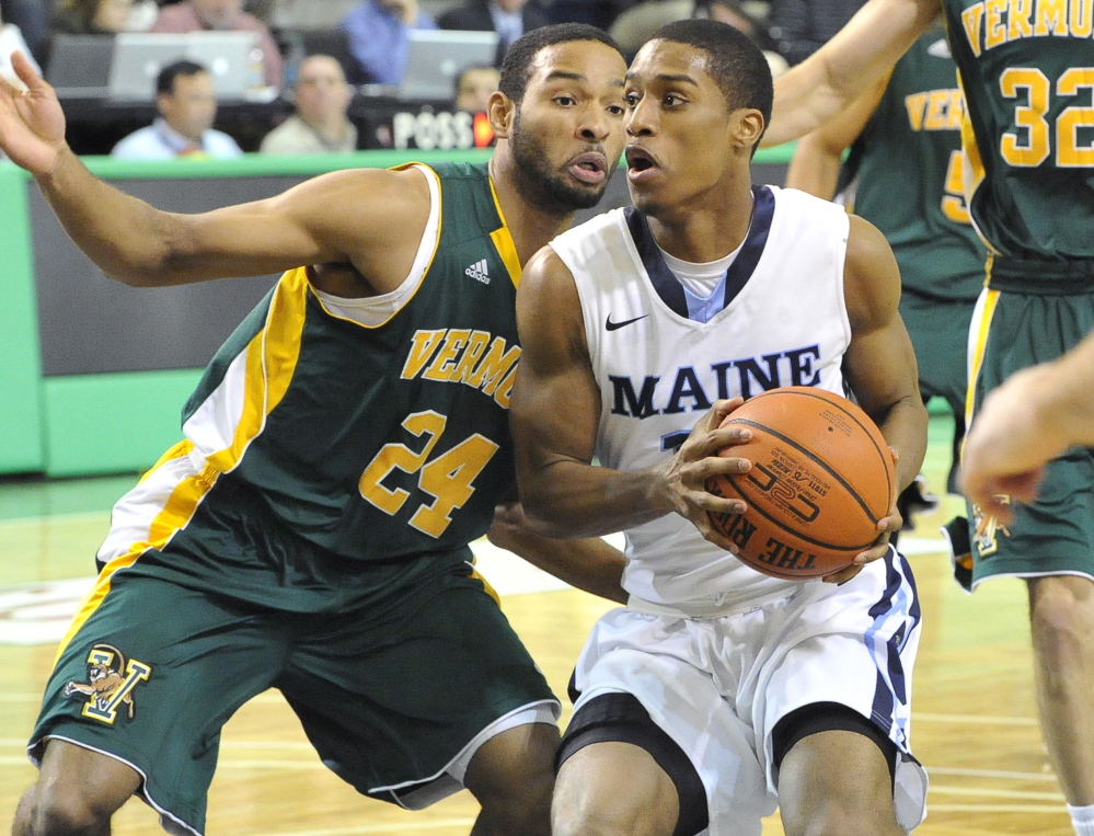 UMaine’s Shaun Lawton looks for room against Dre Wills of Vermont on Wednesday night at the Portland Expo.