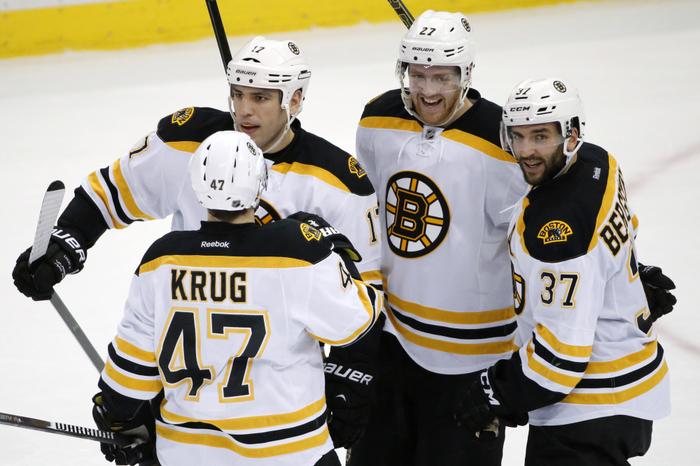Boston’s Patrice Bergeron (37) celebrates his overtime goal against the Pittsburgh Penguins on Wednesday night in Pittsburgh. The Bruins won, 3-2, to end a three-game losing streak.