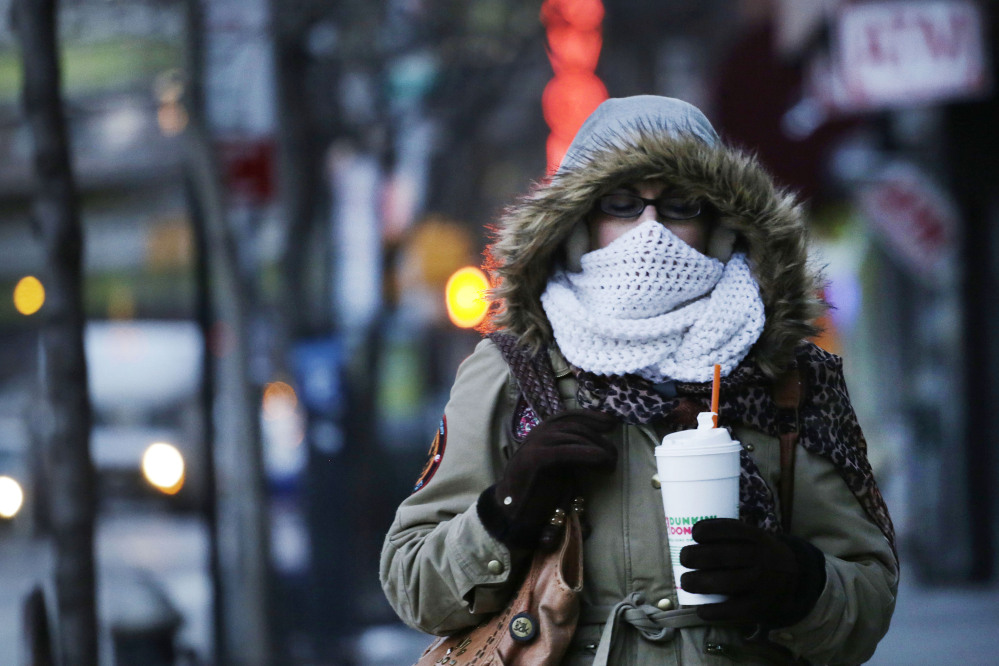 A New Yorker clutches a foam cup as she makes her way down a chilly street Thursday shortly before New York Mayor Bill de Blasio announced a ban on foam containers.