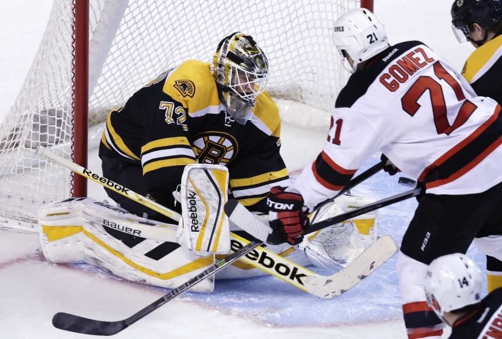Boston Bruins goalie Niklas Svedberg makes a save as New Jersey Devils center Scott Gomez looks for the rebound during the first period of Thursday night’s 3-0 win by the Bruins in Boston.