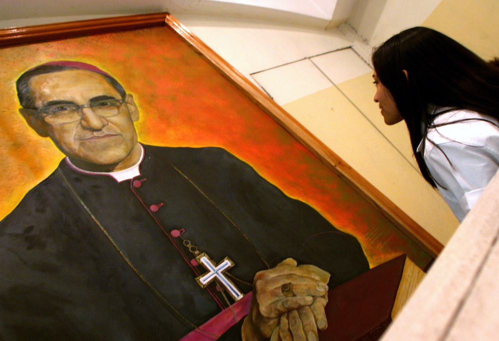 A woman views an image of Archbishop Oscar Romero, who was gunned down while celebrating Mass on March 24, 1980. Avvenire, a newspaper of the Italian bishops’ conference, reports that Romero has been designated a martyr.