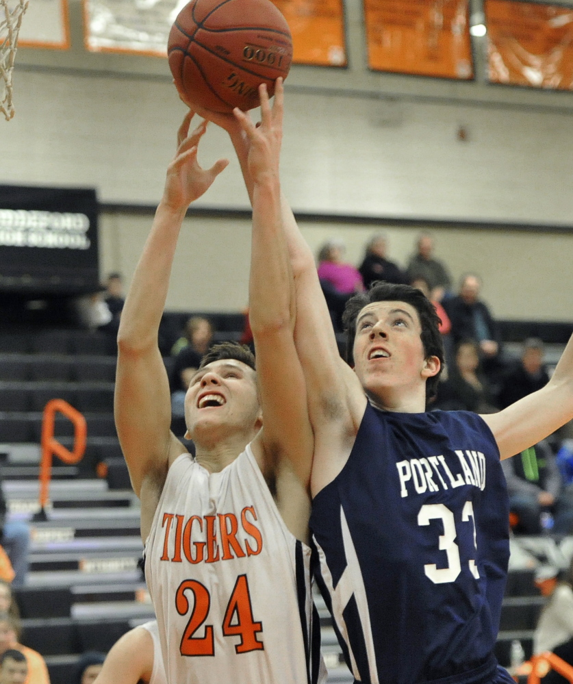 Ben Griffin of Portland, right, attempts to reach over Codie Ramos of Biddeford for a rebound. Portland remained undefeated in nine games and dropped the Tigers to a 1-9 record.