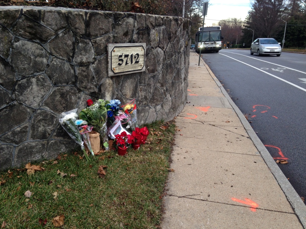 In this Dec. 29, 2014 file photo, flowers and messages are placed at the scene of a fatal collision between a car and bicyclist along a Baltimore residential street with a bike lane.