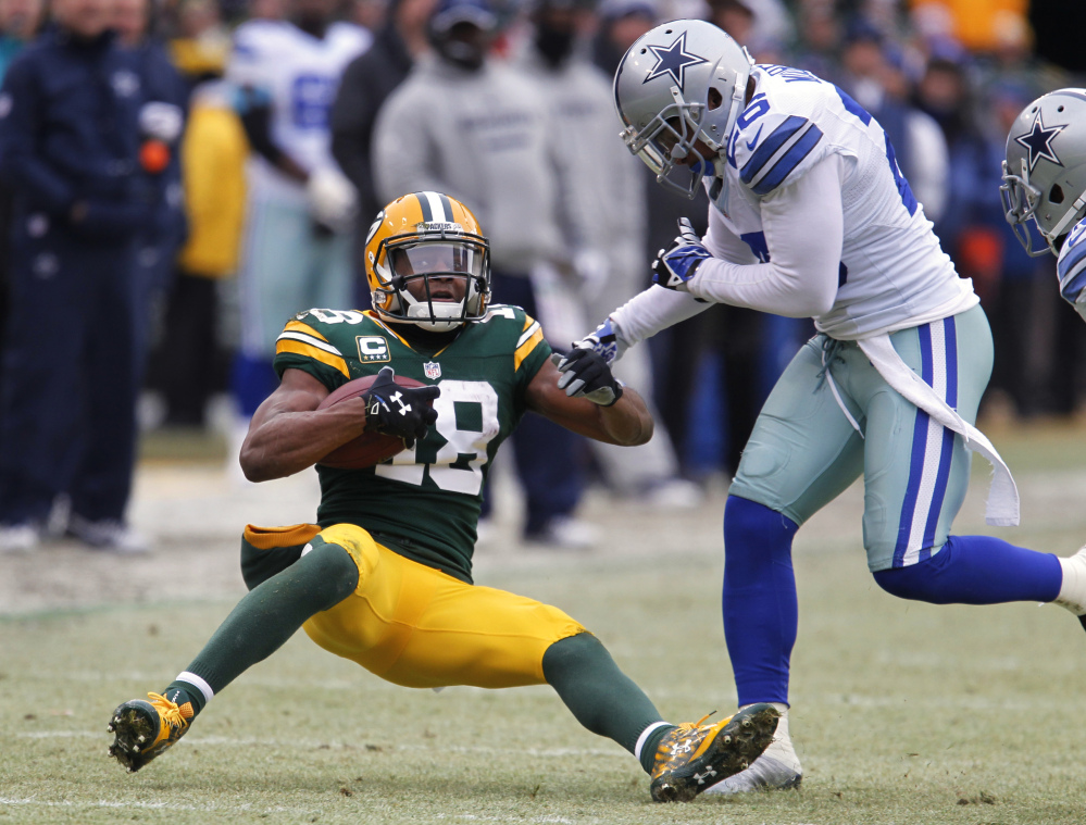 Green Bay wide receiver Randall Cobb spins to avoid a tackle by Cowboys defensive back Sterling Moore in the first half Sunday in Green Bay, Wis.