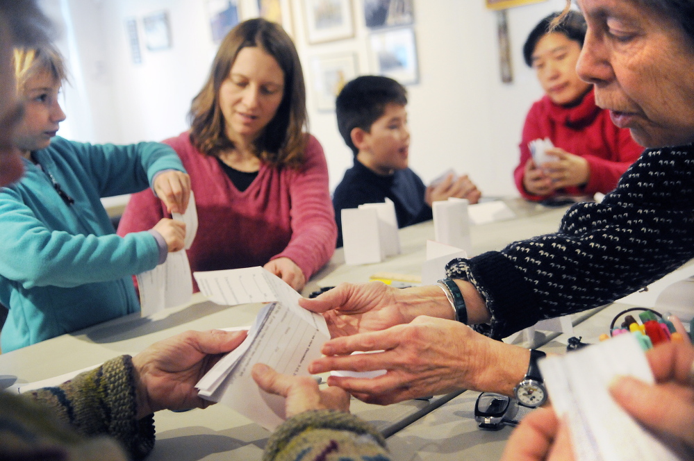 Margo Ogden, right, shows how to fold paper into books during a class at Harlow Gallery in Hallowell during a free Second Sunday event that ties the arts to the community.
