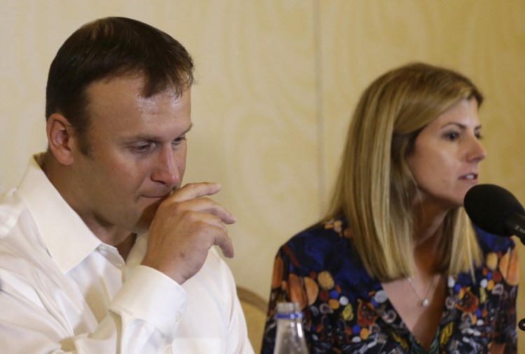 Former Miami Dolphins fullback Rod Konrad listens while his wife, Tammy, responds to a question during a news conference Monday at which he described his ordeal of swimming to shore after he fell off his boat while fishing last week off the South Florida coast.