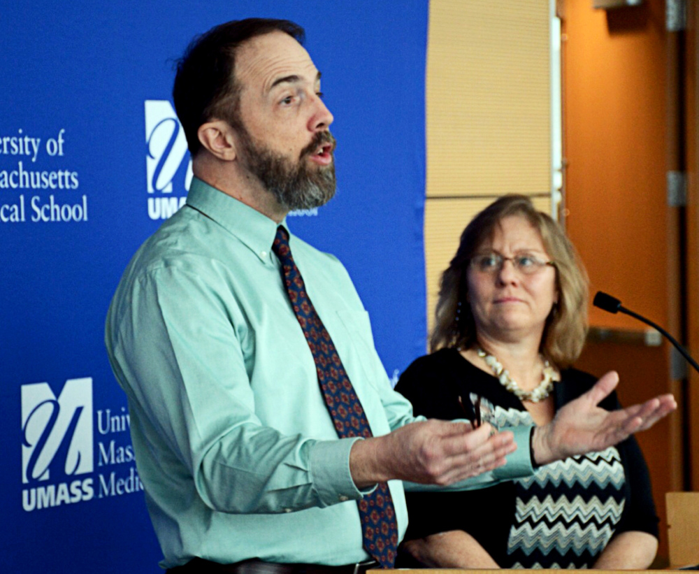 Dr. Rick Sacra talks about going to work with Ebola patients as his wife, Debbie, listens Monday in Worcester, Mass.