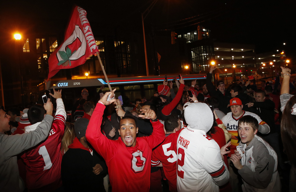 Ohio State students celebrate, early Tuesday, at the Student Union on High Street in Columbus, Ohio, following their team’s win in the NCAA National Championship football game against Oregon.
