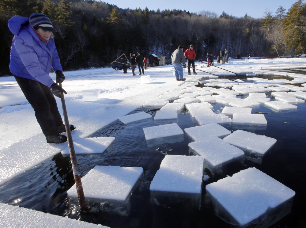 Jane Kellogg guides ice blocks weighing 120 to 160 pounds each. The annual tradition of harvesting lake ice goes back a century.